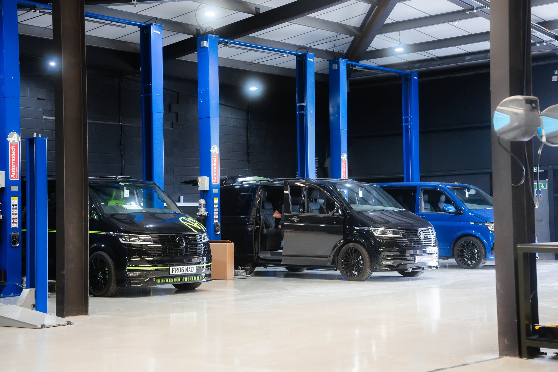 Custom vans on the lifts inside the Van Haven Dorset workshop